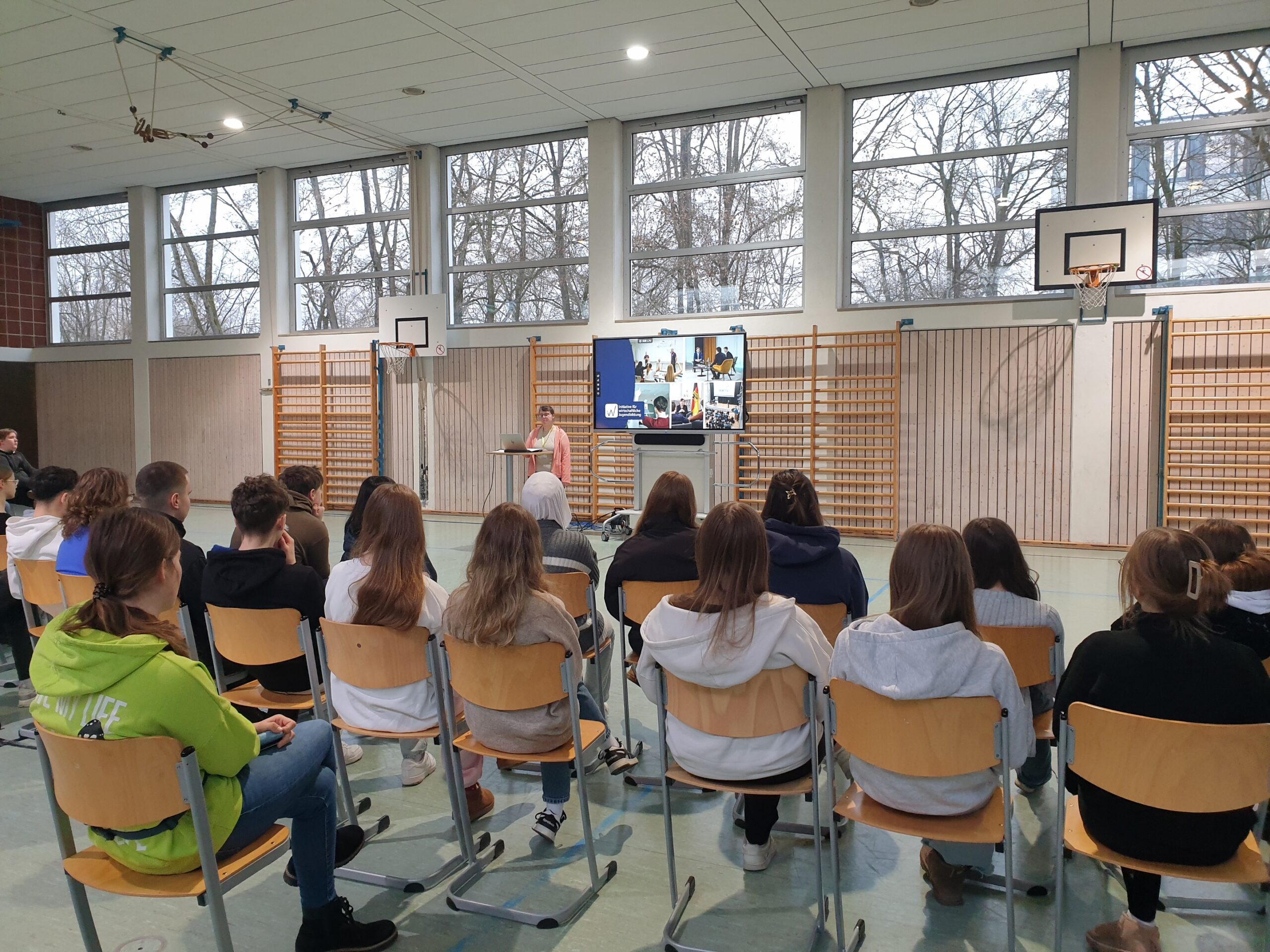 Schüler hören Präsentation in der Turnhalle zu